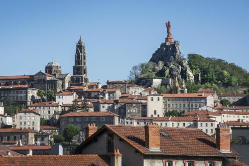 a bunch of buildings in a city with a hill at Deltour Hotel Le Puy En Velay in Le Puy en Velay