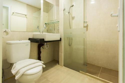 y baño con aseo, lavabo y ducha. en Best Inn Balikpapan, en Balikpapan