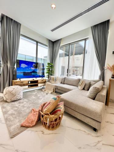 Una sala de estar con un sofá y un televisor. en Rosella Chalet, en Qurayyah