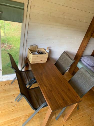 a wooden table with chairs and a box on it at Orupõhja kämpingud ja telkimisala in Põlva