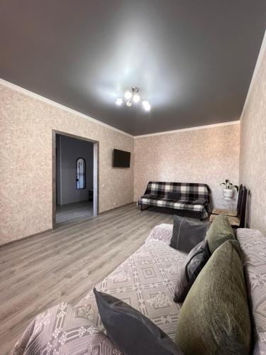 uma sala de estar com uma cama e um sofá em Квартира в центре города посуточно, понедельно em Kokshetau