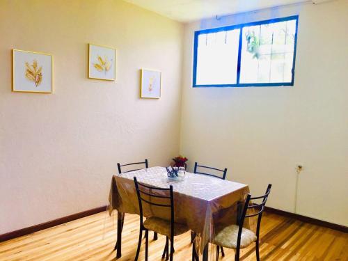 a dining room with a table with chairs and a window at View n Wide/Green Place in Cuenca