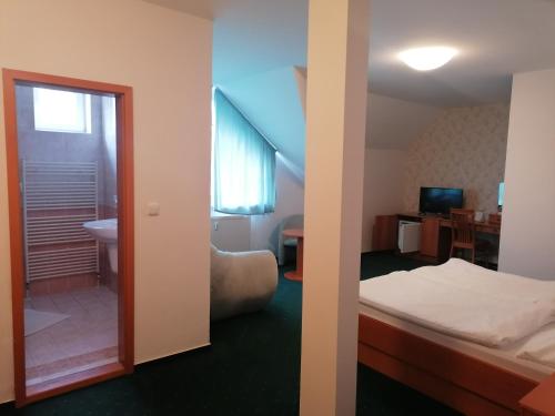 A bed or beds in a room at Hotel Kaskáda