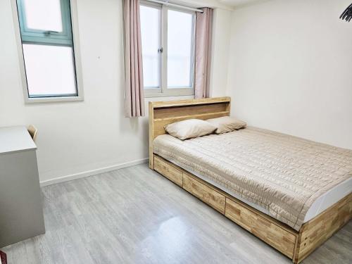 a bedroom with a bed and two windows at BoA Travel House in Seoul