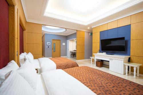 a hotel room with two beds and a flat screen tv at Hotel Core in Naju