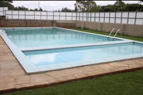 a large swimming pool in a yard at Milimani Furnished Apartments in Nakuru