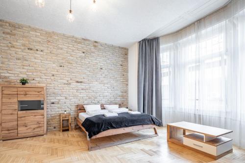 Un dormitorio con una cama y una pared de ladrillo. en Luxurious Apartments At City Center, en Budapest