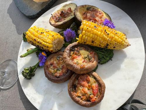 a plate of food with corn and vegetables on it at NavaGarden-panorama rest and spa in Balatonkenese
