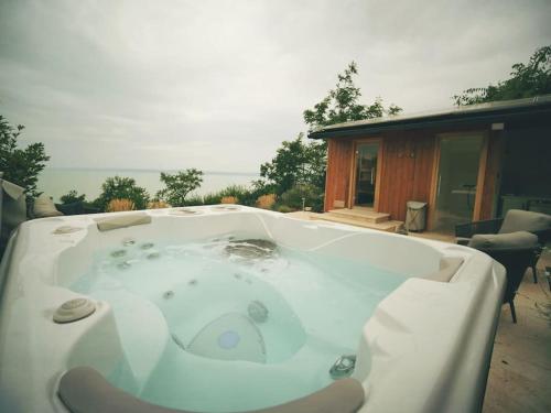 a hot tub on a patio with a house at NavaGarden-panorama rest and spa in Balatonkenese