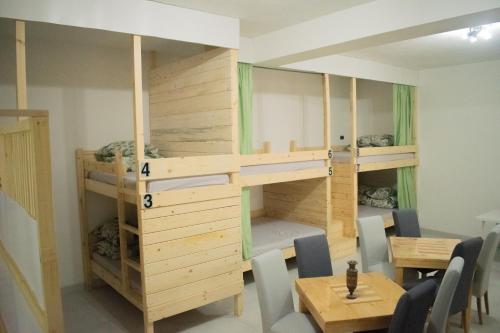 a room with bunk beds and a table and chairs at Hostel Kovači in Sarajevo