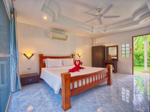 卡圖的住宿－Serenity Lakeside Resort，一间卧室,床上有红色的弓
