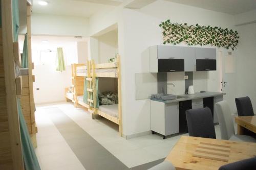 Zimmer mit einem Schreibtisch und einem Etagenbett in der Unterkunft Hostel Kovači in Sarajevo