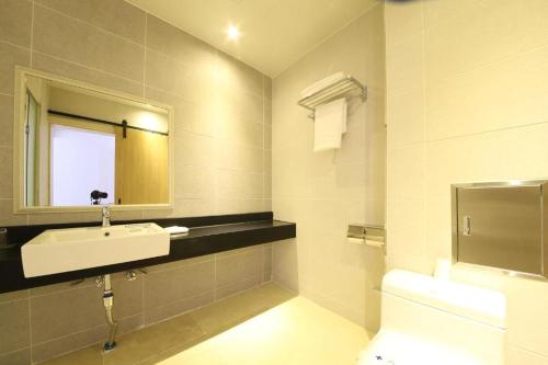 a bathroom with a sink and a toilet and a mirror at Lake 45 Hotel in Naju