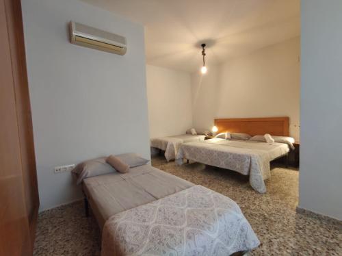um quarto de hotel com duas camas e um aquecedor em LOW COST-PERGAR TORRENUEVA COSTA-wifi em Torrenueva