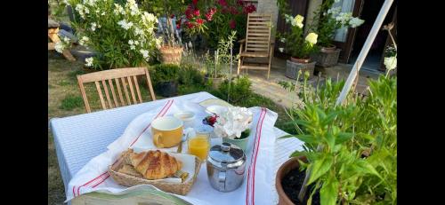 una mesa de picnic con una cesta de pan y zumo de naranja en Une envie de montagne, en Guillestre