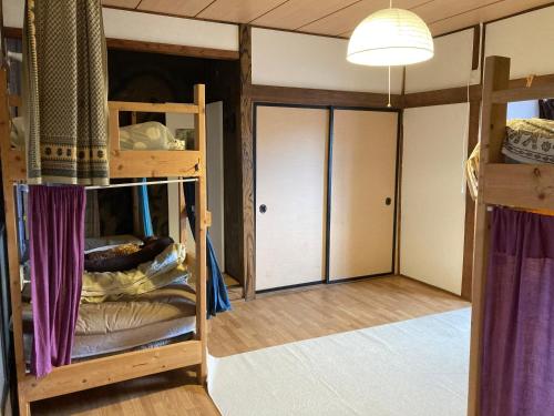 Habitación con 2 literas y pasillo. en Emina Backpackers, en Otaru