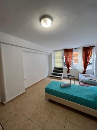 1 dormitorio con 1 cama y 2 ventanas en Eco urban apartemt, en Atenas