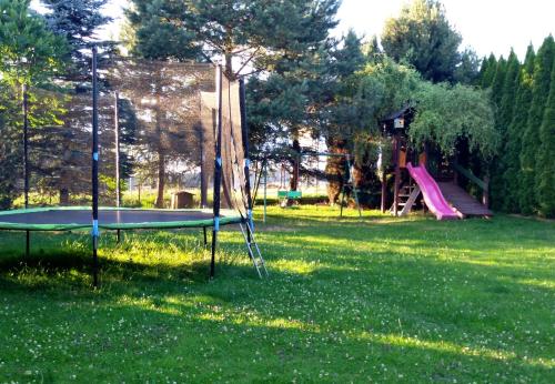 a playground with a trampoline in the grass at Pod Jednym Dachem in Skawa