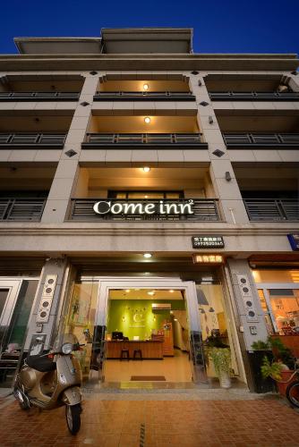 a scooter is parked in front of a store at 康逸旅宿Comeinn2 in Hengchun