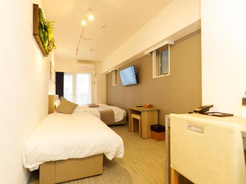 福岡市にあるプレジデントホテル博多のベッド2台とテレビがあるホテルの部屋