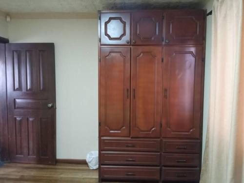 a large wooden cabinet in a room with a door at ABNorth4B Family in Cuenca