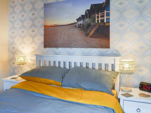 a bedroom with a bed and a picture of a beach at Seaside Dreams in Bessingby