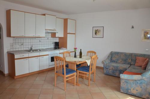 een keuken met een tafel en stoelen en een bank bij Ansitz Weissenheim in Appiano sulla Strada del Vino