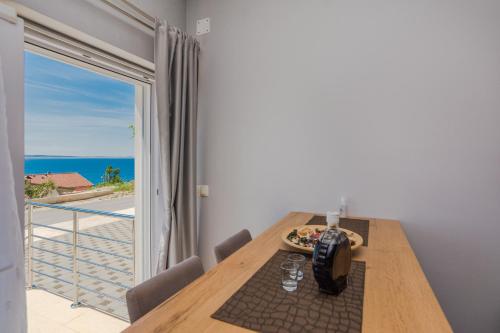 a dining room table with a view of the ocean at Apartmani Jadranka in Starigrad-Paklenica