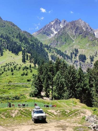 a car parked on the side of a mountain at Rakaposhi Amin Hotel & Restaurant Pissan Hunza Nagar Gilgit Baltistan in Gilgit