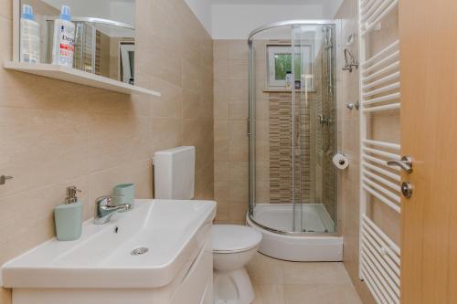 a bathroom with a sink and a toilet and a shower at Apartmani Jadranka in Starigrad-Paklenica