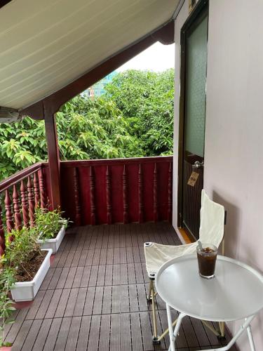 a wooden balcony with a white table and chairs on it at Mai Anh Homestay Long Hải in Long Hai