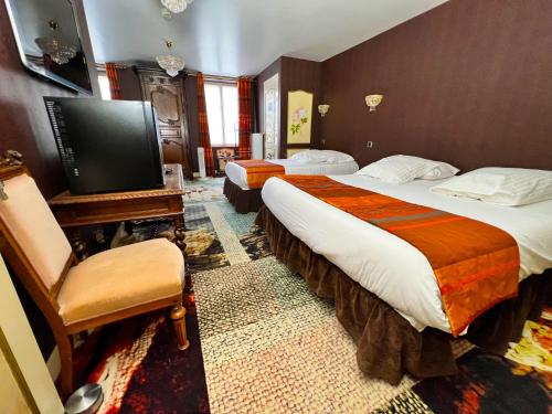 a hotel room with two beds and a flat screen tv at Hotel De La Poste in Langres