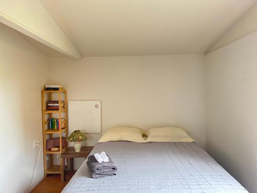 a bedroom with a bed and a book shelf at Kukumoa Cabin in Opotiki