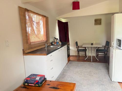 a kitchen with a sink and a table at Kukumoa Cabin in Opotiki