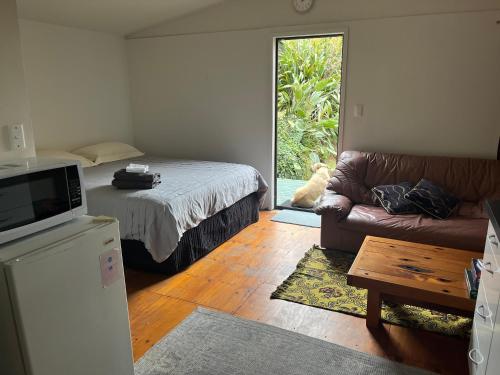 a living room with a bed and a couch at Kukumoa Cabin in Opotiki