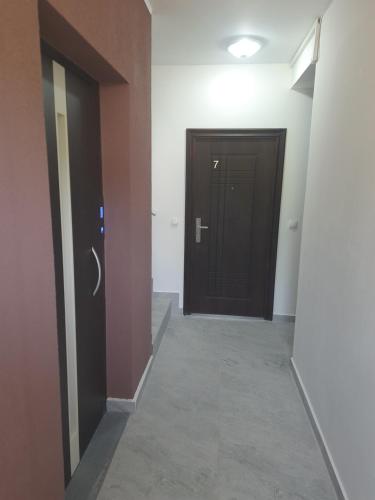 a hallway with a black door and a hallwayngth at Nino Lux Apartments Ulcinj in Ulcinj