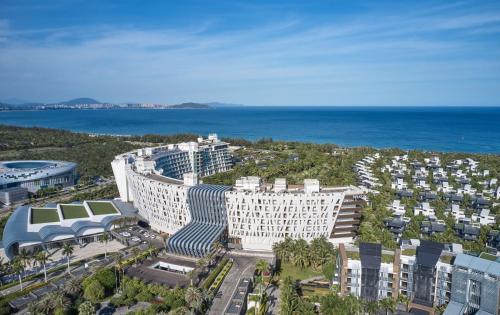 een luchtzicht op een groot gebouw in de buurt van de oceaan bij The Westin Sanya Haitang Bay Resort in Sanya