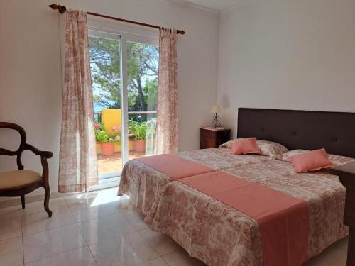 een slaapkamer met een bed en een groot raam bij PuntBlanc Residences in Sant Elm