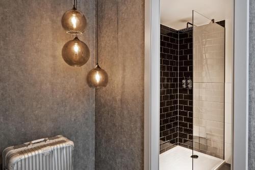 a bathroom with two pendant lights and a shower at THE SCOTTY Hotel Hamburg in Hamburg
