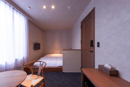 a bedroom with a bed and a desk and a table at NODE SAIGAWA in Kanazawa