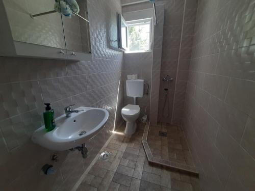 a bathroom with a sink and a toilet and a window at Nino Lux Apartments Ulcinj in Ulcinj
