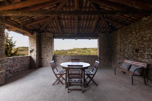 eine Terrasse mit einem Tisch und Stühlen in einem Gebäude in der Unterkunft Ca der Forn the Bread Oven House in Cascina Bricchetto Langhe - Italy in Trezzo Tinella