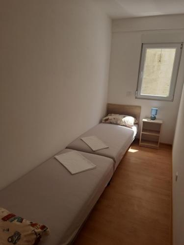 a small bedroom with a bed and a window at Nino Lux Apartments Ulcinj in Ulcinj