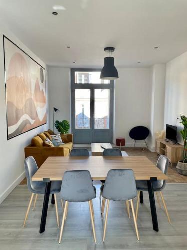 un salon avec une table et des chaises en bois dans l'établissement Joli T4 en centre historique, à Montauban