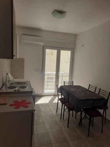 a kitchen and dining room with a table and chairs at Nino Lux Apartments Ulcinj in Ulcinj