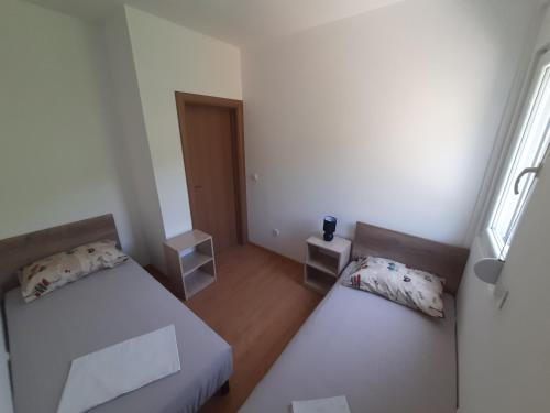 a small room with two beds and a window at Nino Lux Apartments Ulcinj in Ulcinj