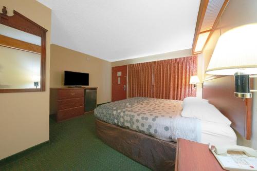 a hotel room with a bed and a desk with a phone at Broadway Inn Portland Downtown in Portland