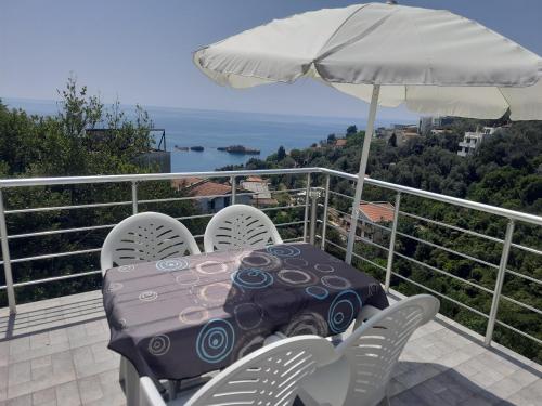 a table and chairs on a balcony with an umbrella at Nino Lux Apartments Ulcinj in Ulcinj
