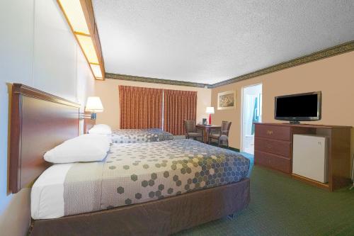 ein Hotelzimmer mit einem Bett und einem Flachbild-TV in der Unterkunft Broadway Inn by OYO Portland Downtown in Portland