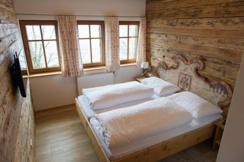 a bedroom with a bed with a wooden wall at Gmundnerberghaus in Altmünster